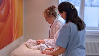 Erfahrene Kinderärztin untersucht Säugling bei der U1-Untersuchung in München-Nord.