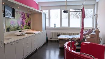 Moderne Geburtsklinik in München-Nord: Blick in einen hellen Kreißsaal mit Geburtswanne.